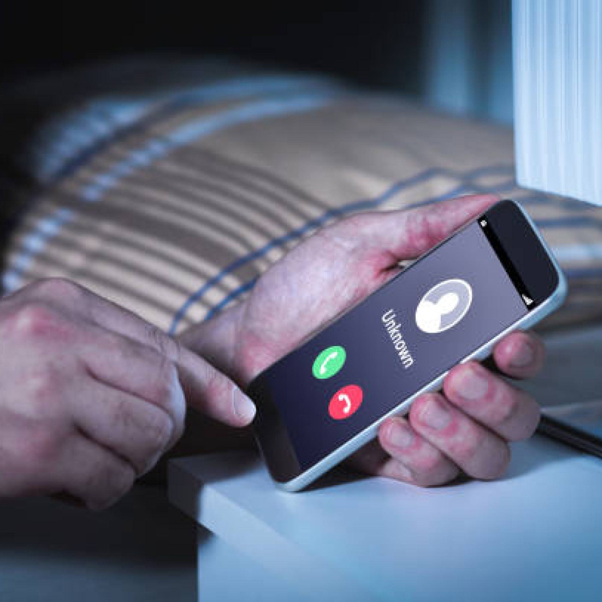 Unknown number calling in the middle of the night. Phone call from stranger. Person holding mobile and smartphone in bedroom bed home late. Unexpected call woke up.