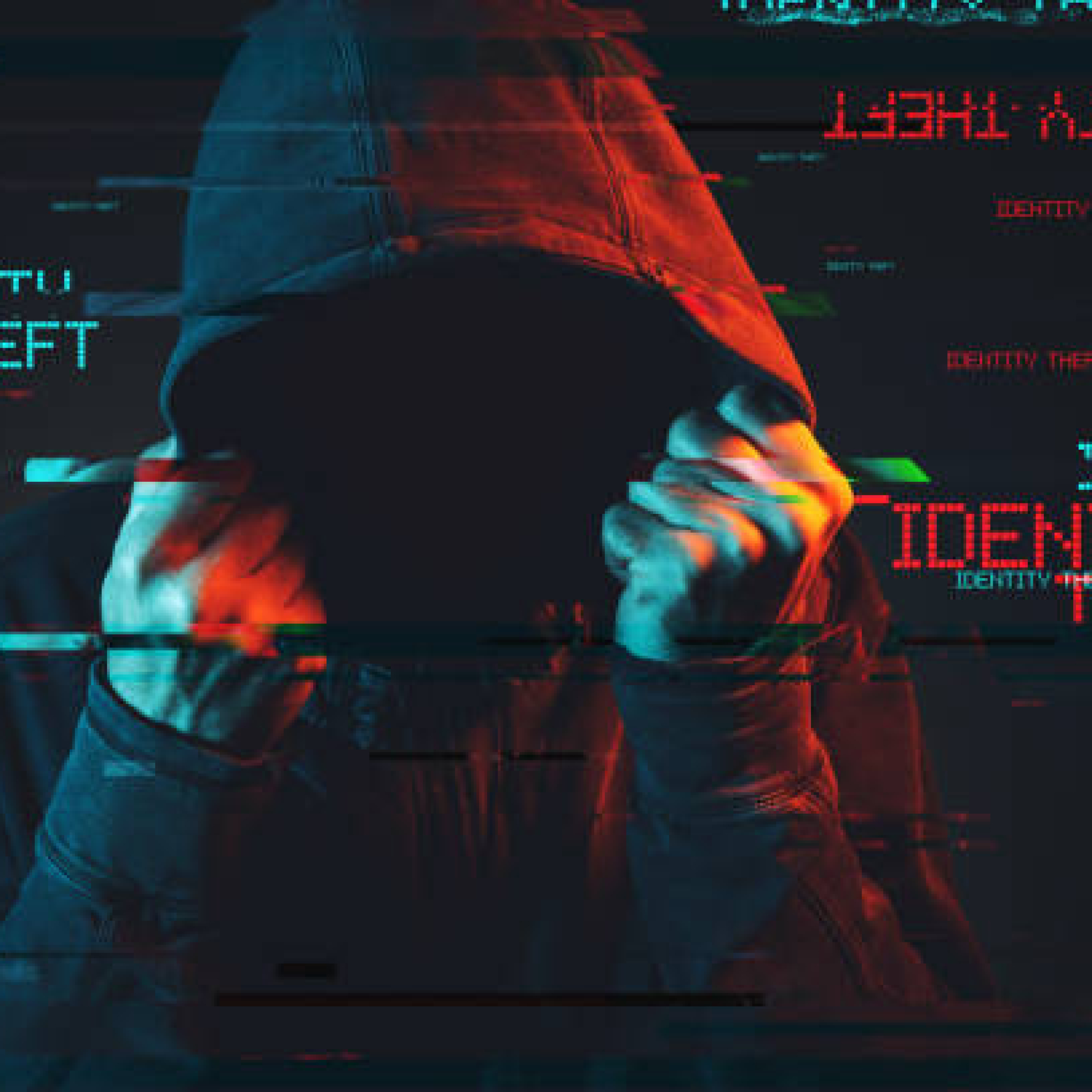 Online identity theft concept with faceless hooded male person, low key red and blue lit image and digital glitch effect